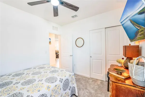 a bedroom with a bed and a lamp on the dresser