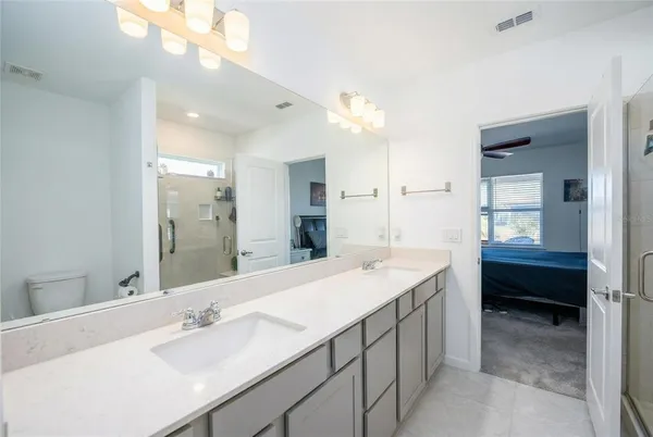a en suite bathroom with a double vanity sink a mirror and a bathtub
