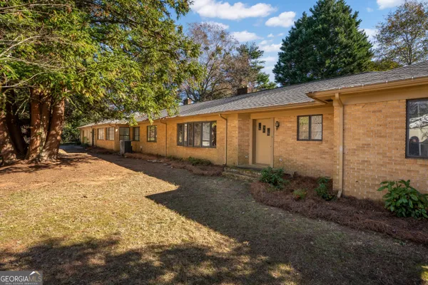 a view of a house with backyard and trees