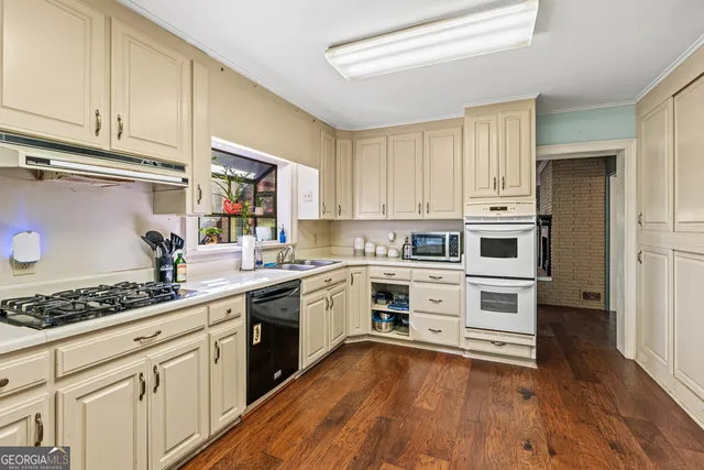 a kitchen with granite countertop a sink stainless steel appliances and cabinets