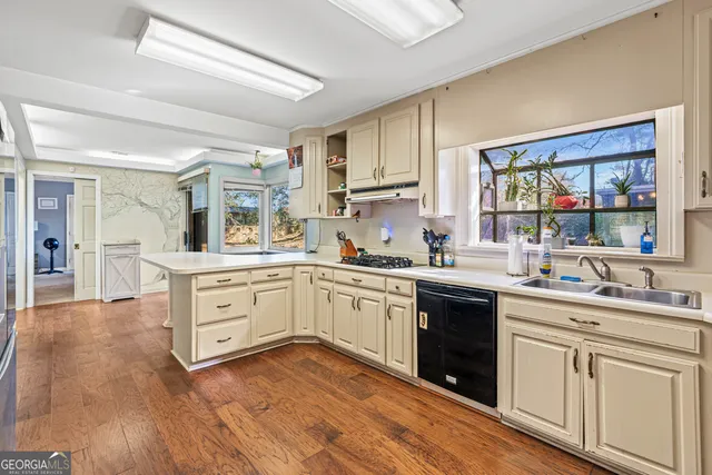 a view of kitchen with stainless steel appliances refrigerator stove and wooden floor