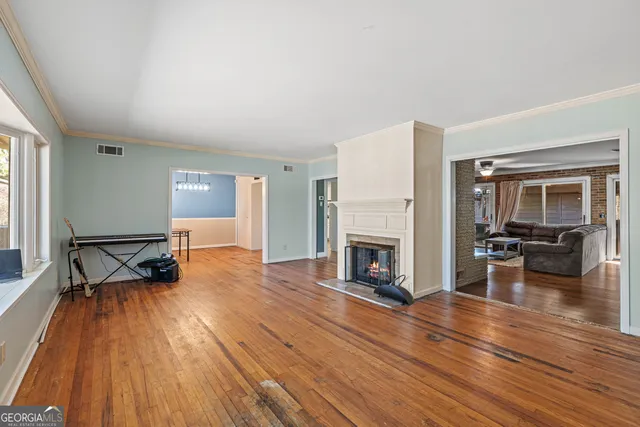 a view of a livingroom with wooden floor and a fireplace