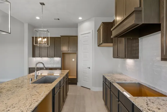 a kitchen with granite countertop stainless steel appliances sink stove microwave and cabinets