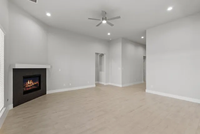an empty room with a fireplace and window