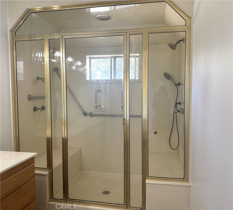 26050 Jan Valerie Road Murrieta, CA 92562 - Photo 30 of 47 a bathroom with a glass shower door and a mirror