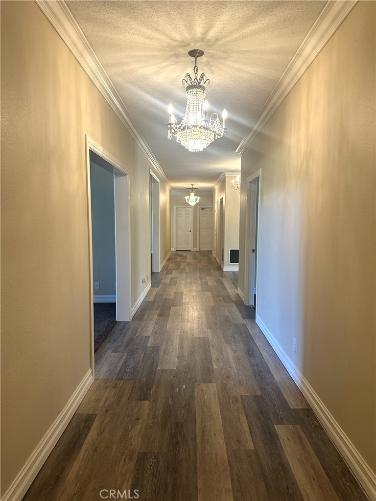 26050 Jan Valerie Road Murrieta, CA 92562 - Photo 35 of 47 a view of a hallway with wooden floor and a chandelier