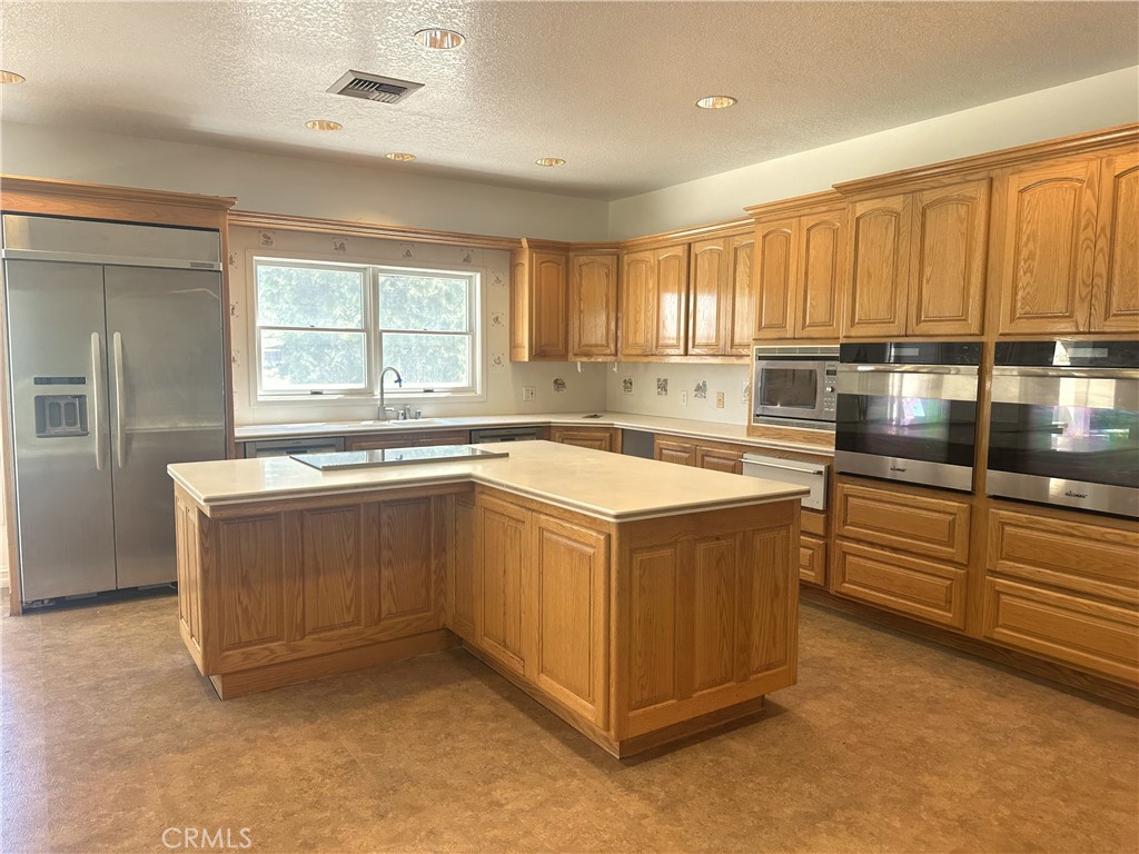 26050 Jan Valerie Road Murrieta, CA 92562 - Photo 6 of 47 a kitchen with a sink stove and cabinets