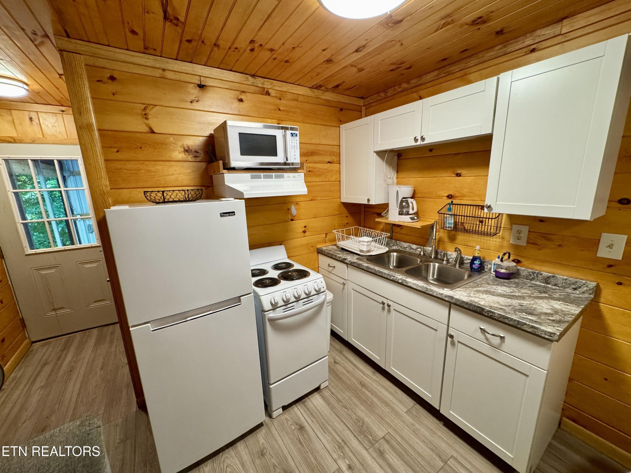 983 River Hill Road Sparta, TN 38583 - Photo 30 of 47 a kitchen with stainless steel appliances a stove a sink a refrigerator a cabinets and wooden floor