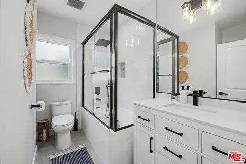 a bathroom with a bathtub shower sink vanity and toilet