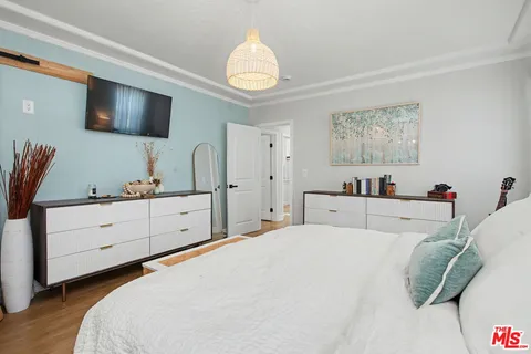 a bedroom with a bed and a flat screen tv