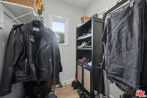 a view of walk in closet with clothes and shoes