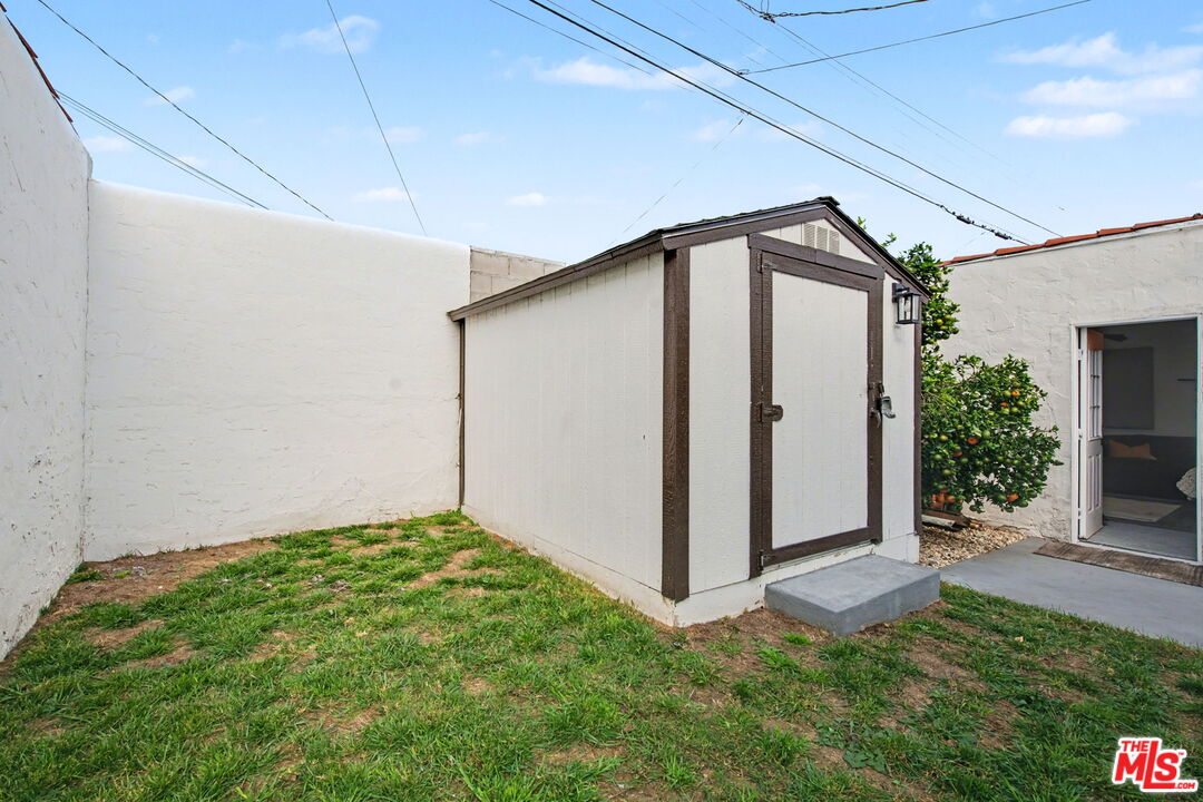 1135 West 81st Place Los Angeles, CA 90044 - Photo 22 of 23 a backyard of a house with plants and a yard