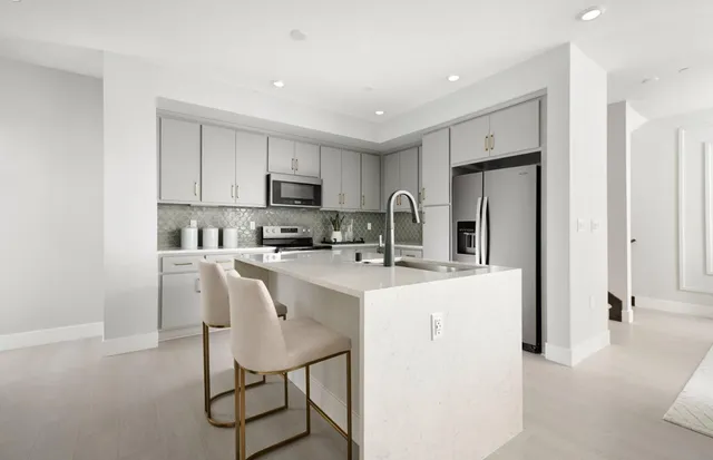 a kitchen with stainless steel appliances granite countertop a refrigerator and a stove top oven