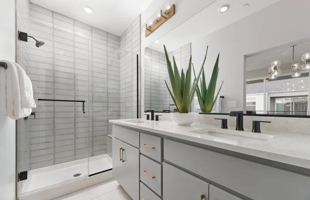 a bathroom with double vanity sink a mirror and shower