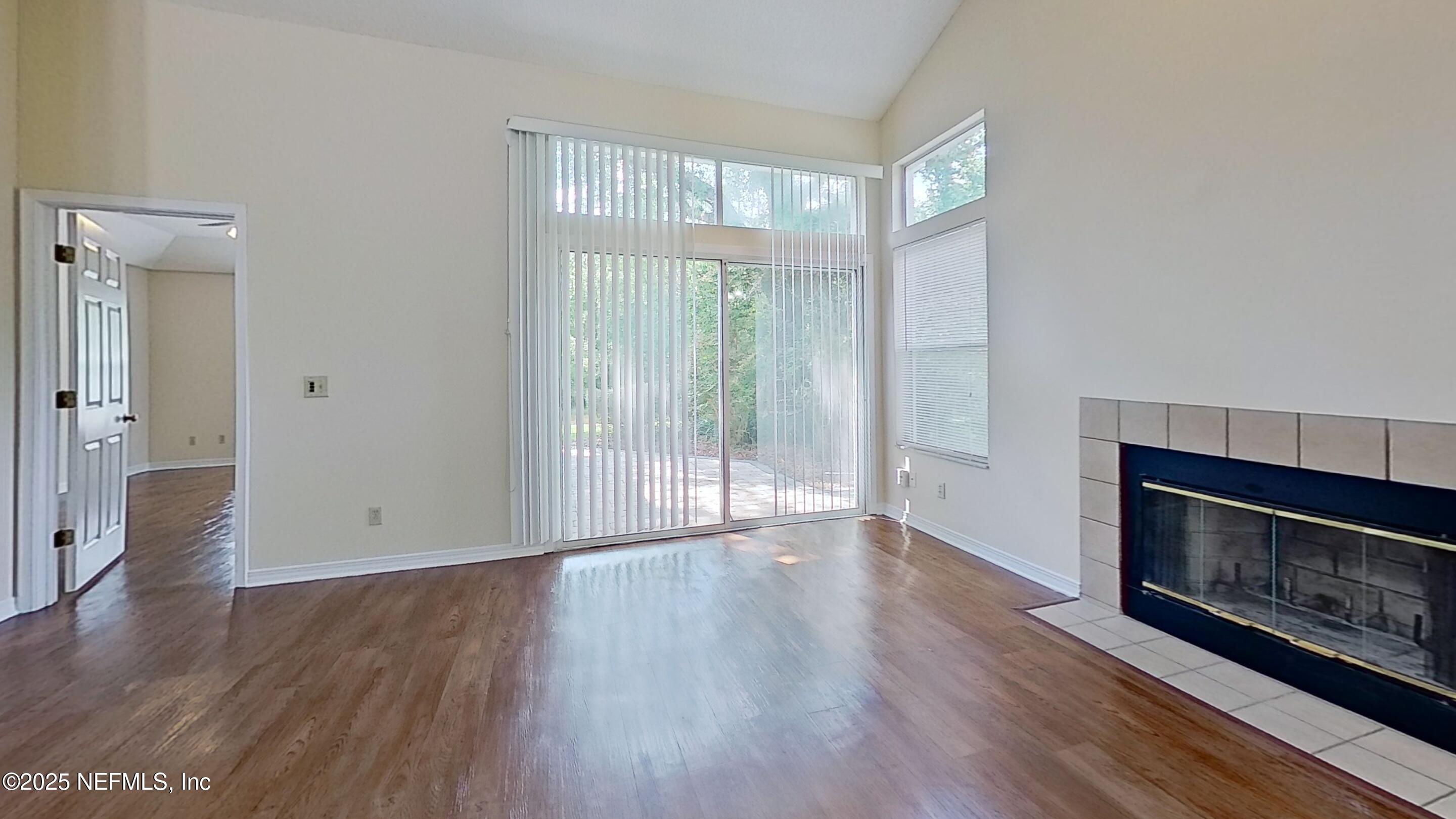 1488 Marsh Rabbit Way Fleming Island, FL 32003 - Photo 12 of 35 a view of an empty room with wooden floor and a window