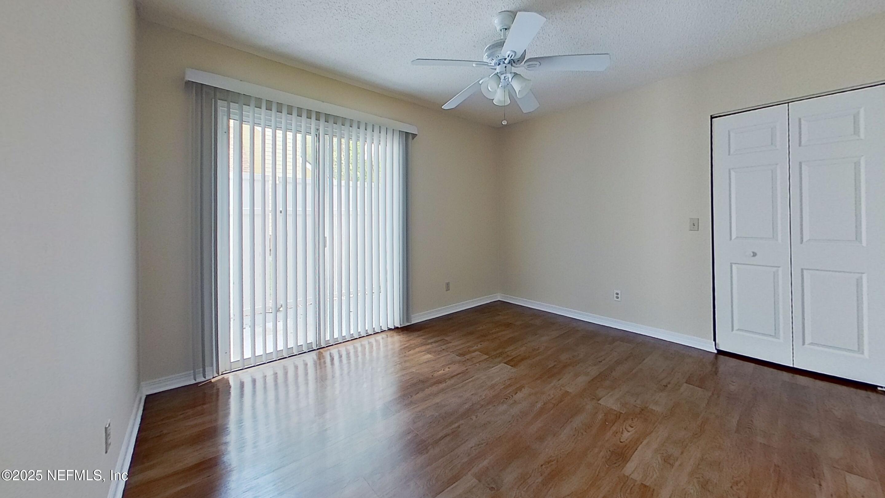 1488 Marsh Rabbit Way Fleming Island, FL 32003 - Photo 17 of 35 a view of an empty room with wooden floor and a window