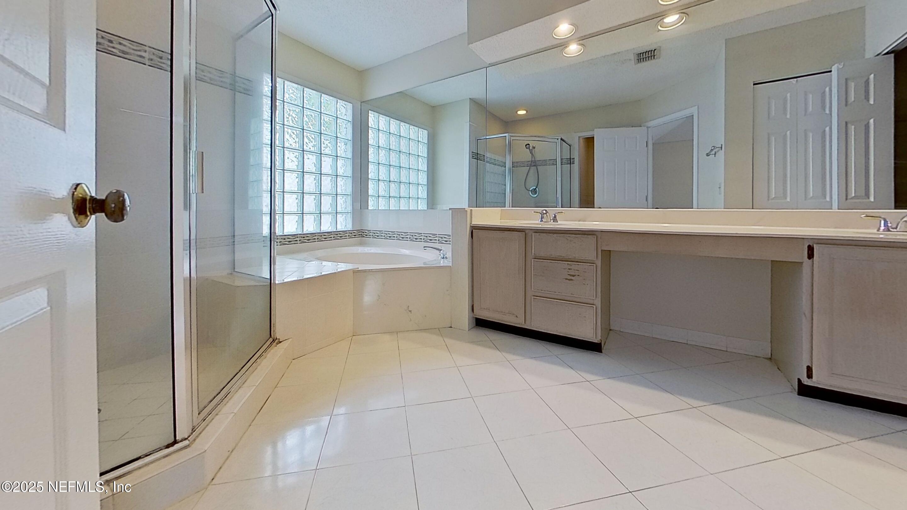 1488 Marsh Rabbit Way Fleming Island, FL 32003 - Photo 27 of 35 a spacious bathroom with a granite countertop sink a mirror and a bathtub