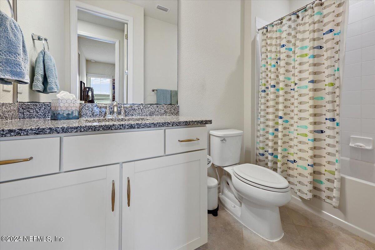 103 Spring Tide Way Ponte Vedra, FL 32081 - Photo 22 of 26 a bathroom with a granite countertop toilet a sink and a mirror