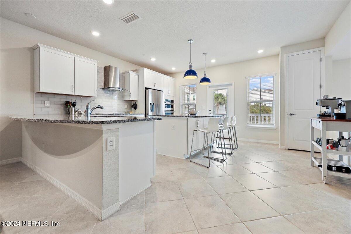 103 Spring Tide Way Ponte Vedra, FL 32081 - Photo 7 of 26 a kitchen with a sink a counter top space appliances and cabinets