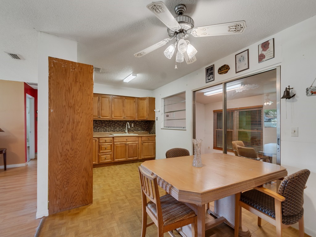418 Maple Street Sebastian, FL 32958 - Photo 11 of 28 a kitchen with stainless steel appliances a table and chairs in it