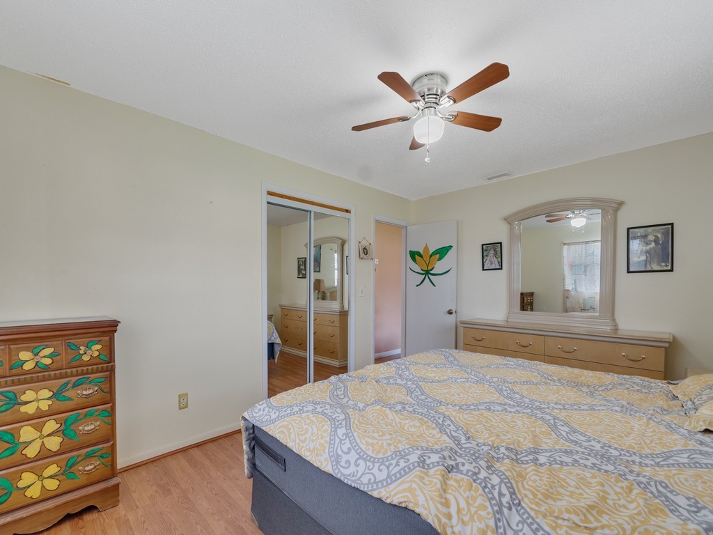 418 Maple Street Sebastian, FL 32958 - Photo 18 of 28 a bedroom with a large bed and a chandelier