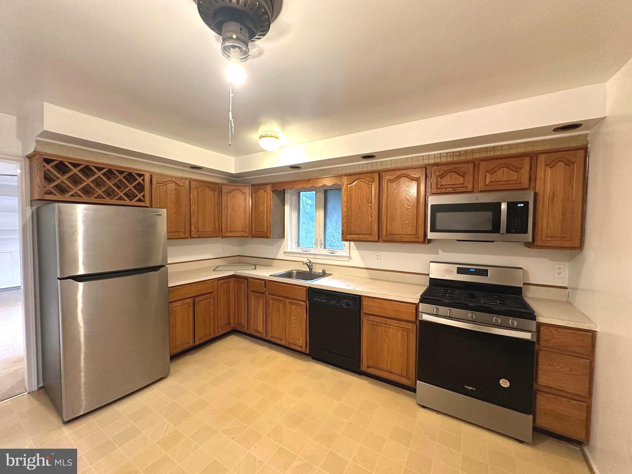 4037 Olney Laytonsville Road Olney, MD 20832 - Photo 11 of 42 a kitchen with stainless steel appliances granite countertop a refrigerator and a stove top oven