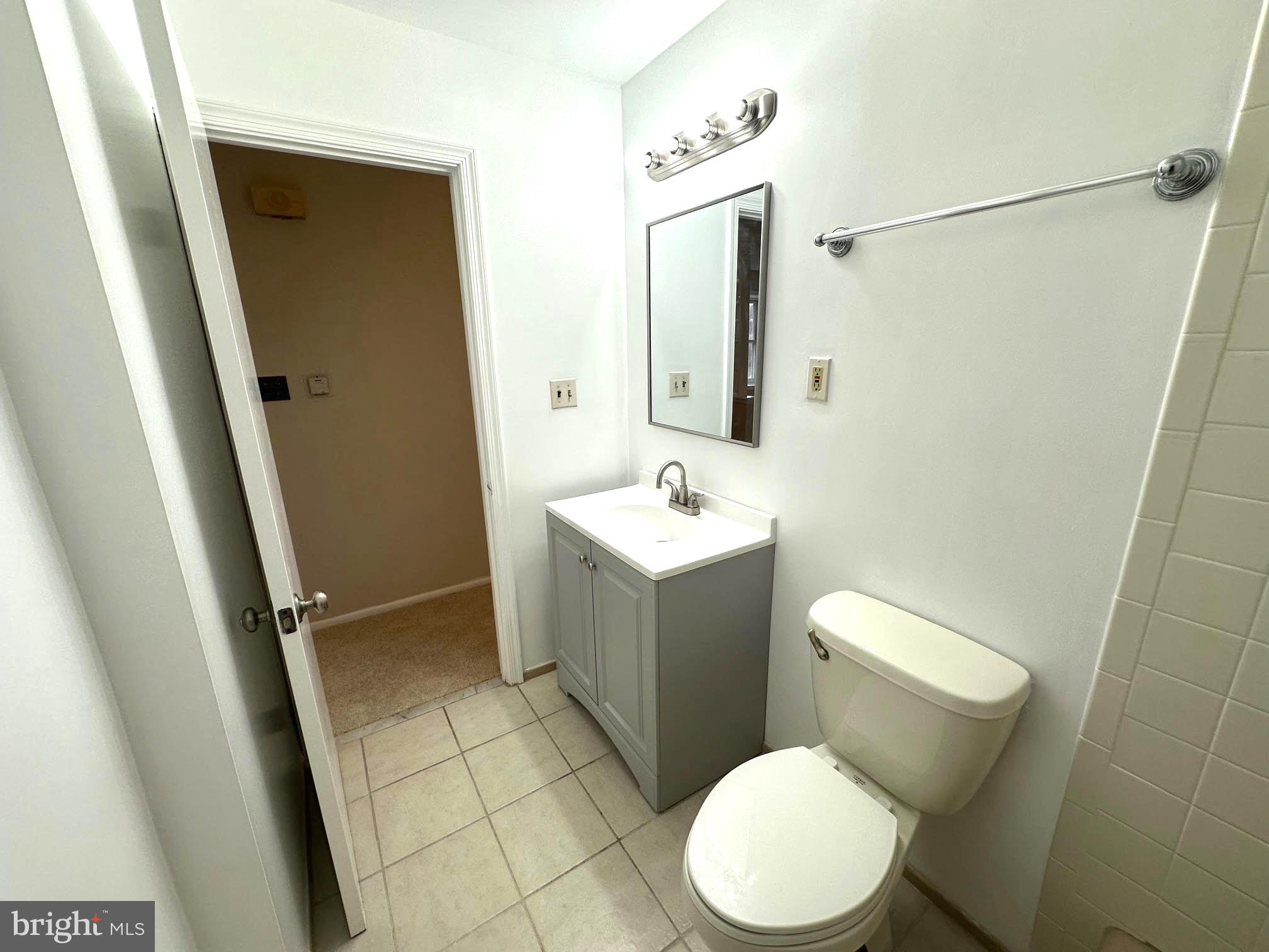 4037 Olney Laytonsville Road Olney, MD 20832 - Photo 19 of 42 a white toilet sitting next to a bathroom sink and a mirror