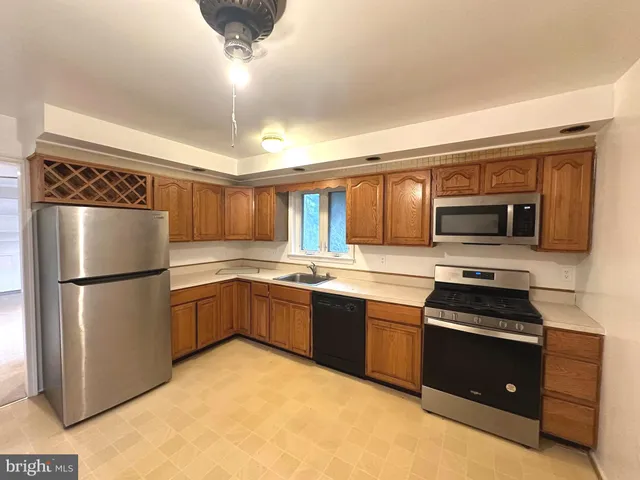 a kitchen with a refrigerator sink and cabinets