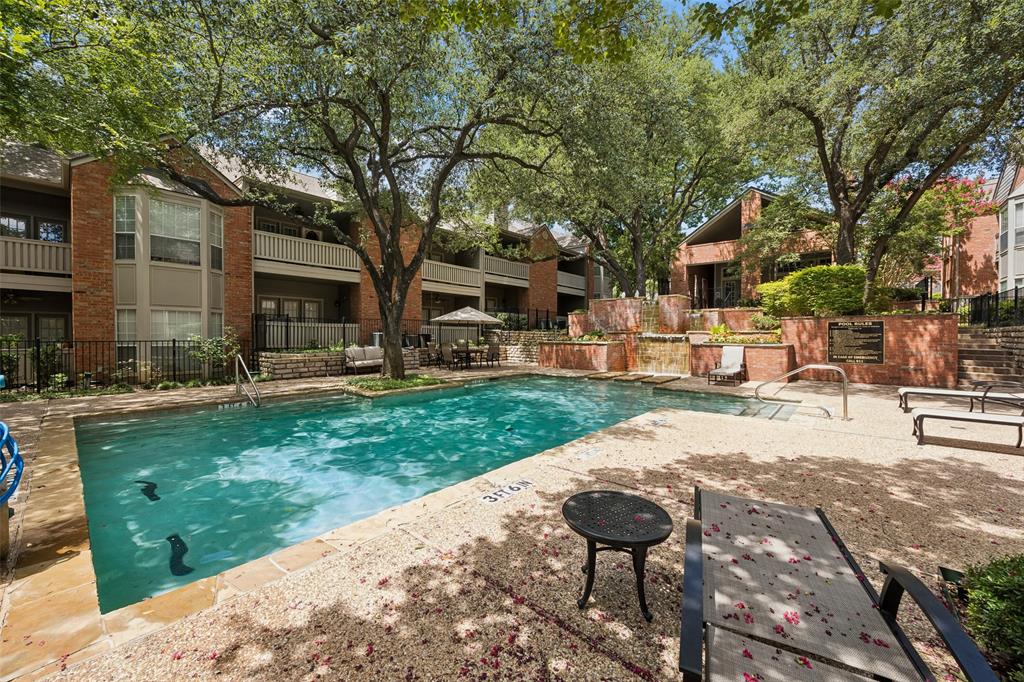 12660 Hillcrest Road, Unit 7205 Dallas, TX 75230 - Photo 23 of 25 Swimming pool area featuring a stone deck, tiered brick planters, and mature shade trees