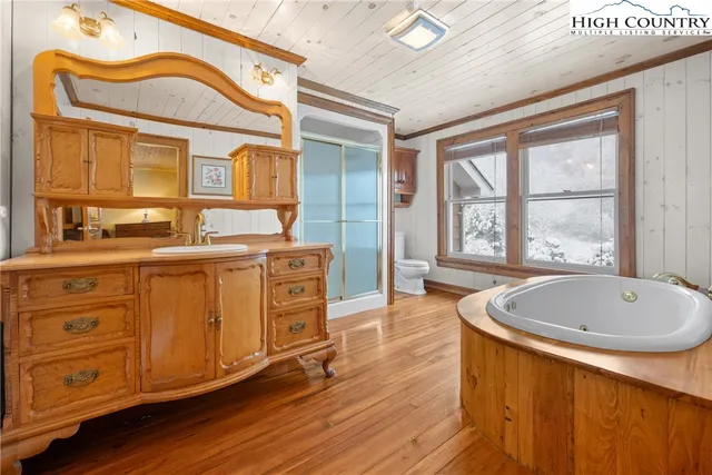 a bathroom with a sink a bathtub a mirror and a window