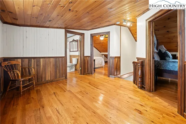 a view of a hallway with wooden floor and chair