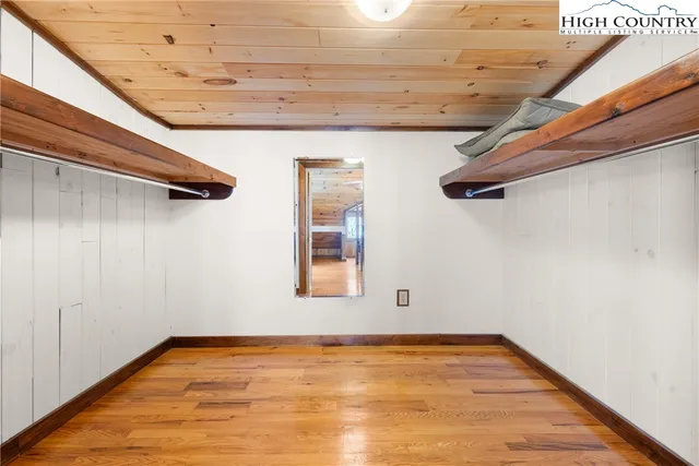 a view of a room with wooden floor and small window