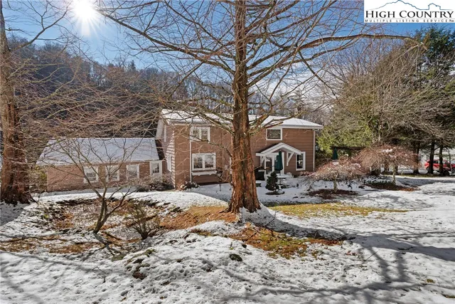 a front view of a house with a yard and potted plants