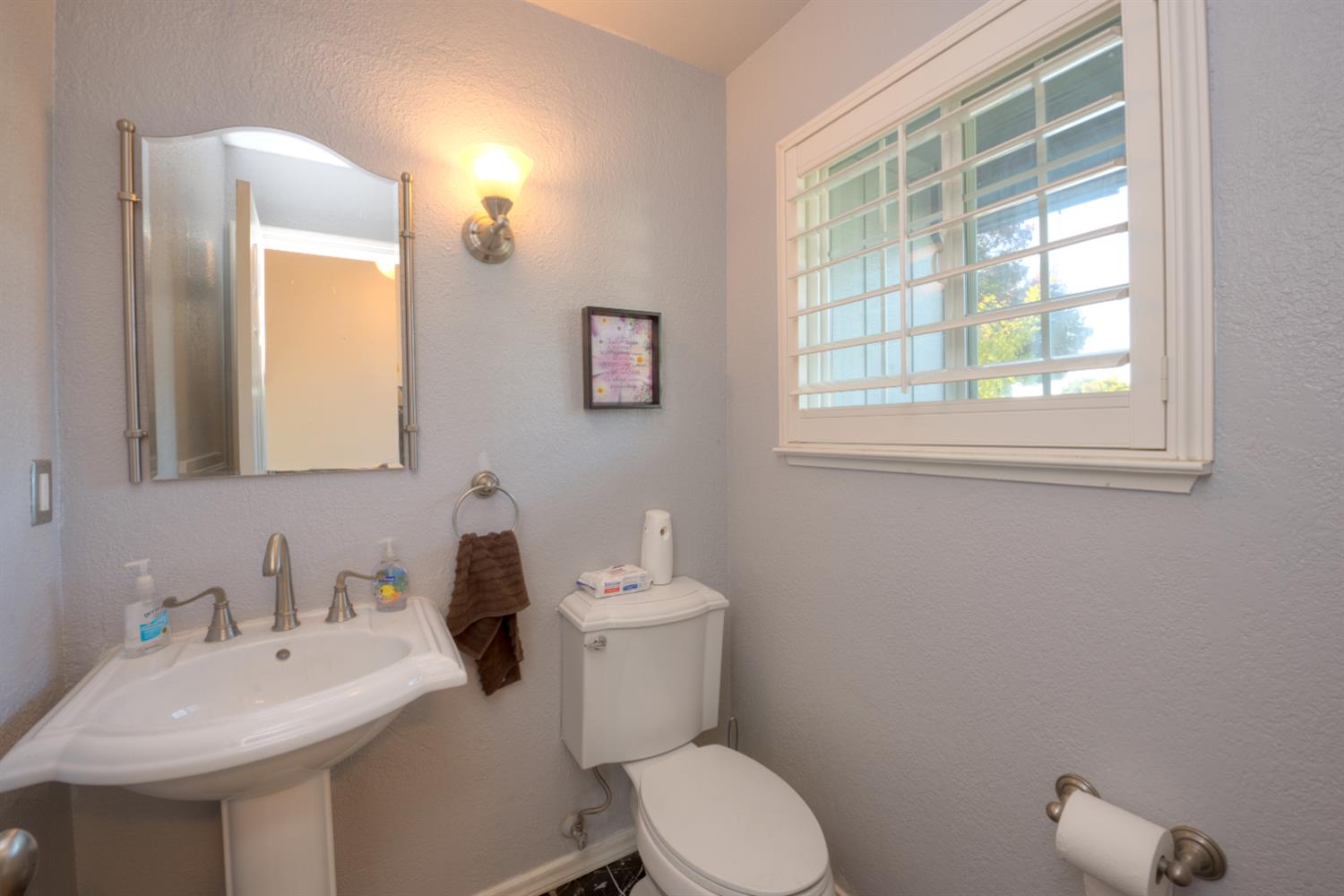 548 Hansen Court Patterson, CA 95363 - Photo 16 of 38 a bathroom with a toilet a sink a mirror and a window