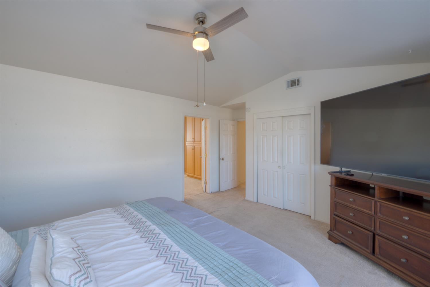 548 Hansen Court Patterson, CA 95363 - Photo 19 of 38 a bedroom with a bed and a chandelier fan