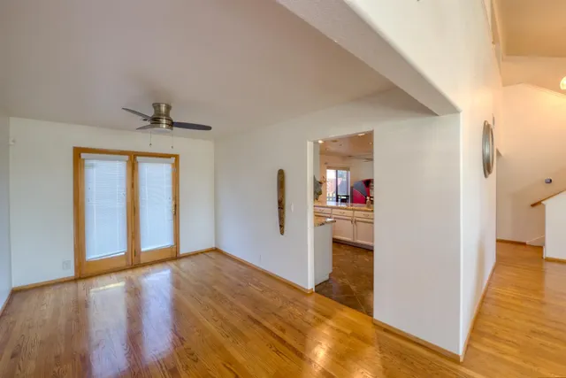 a view of a livingroom with wooden floor and a hallway