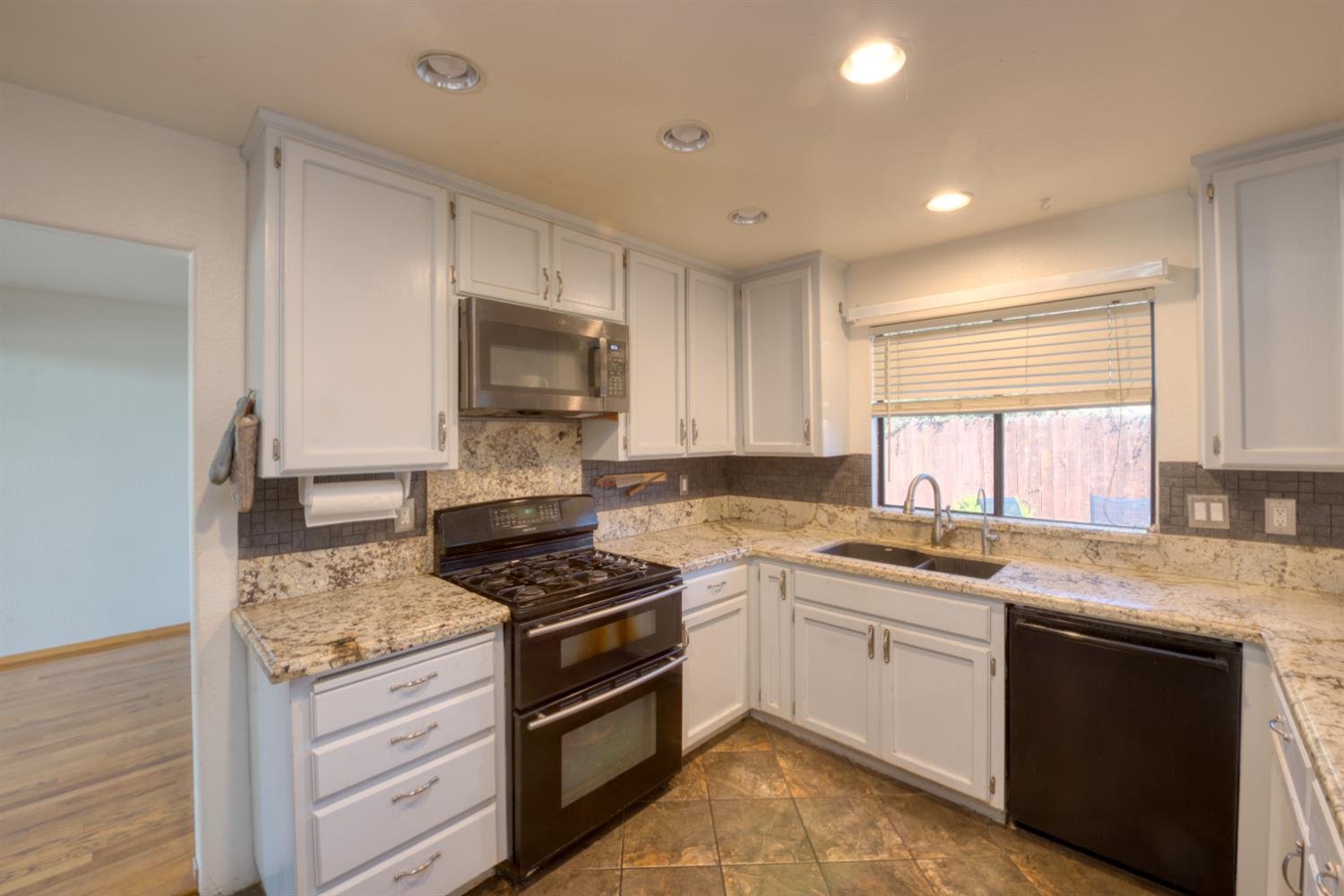 548 Hansen Court Patterson, CA 95363 - Photo 9 of 38 a kitchen with granite countertop a sink stainless steel appliances and cabinets