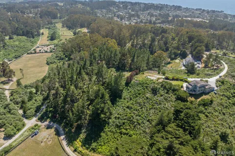 an aerial view of a house with a yard and lake view