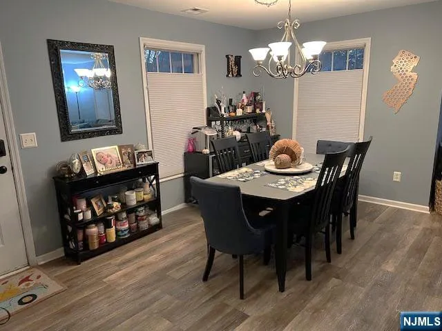 a dining room with furniture a chandelier and wooden floor