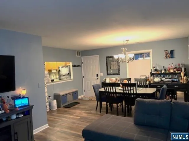 a living room with furniture a flat screen tv and a dining table