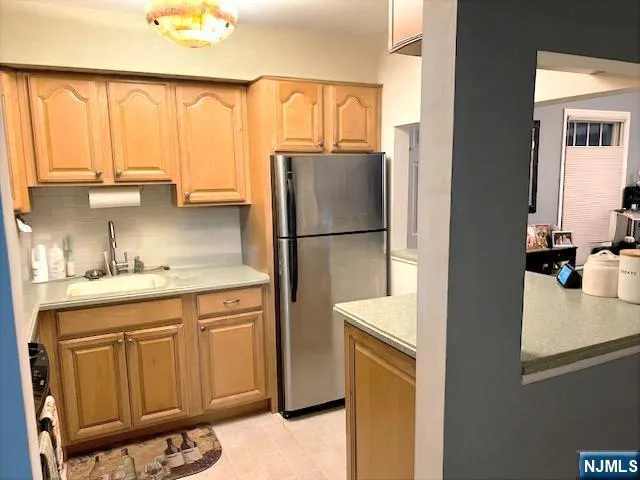 a kitchen with a refrigerator a sink and cabinets