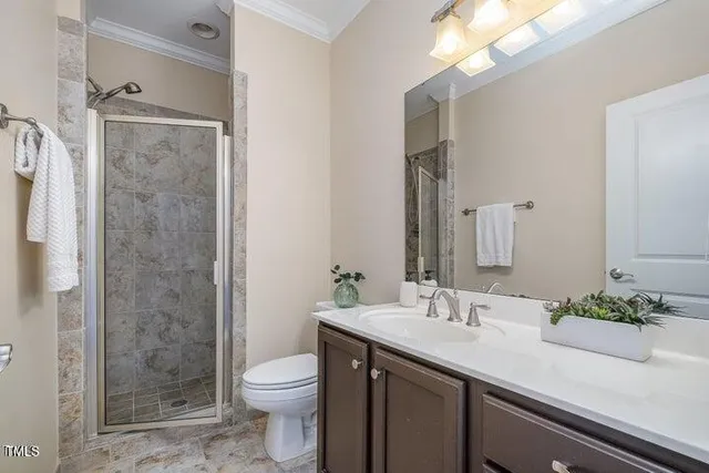 a bathroom with a granite countertop sink a toilet and shower