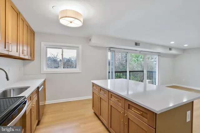 a living room with stainless steel appliances granite countertop a sink a stove and a refrigerator