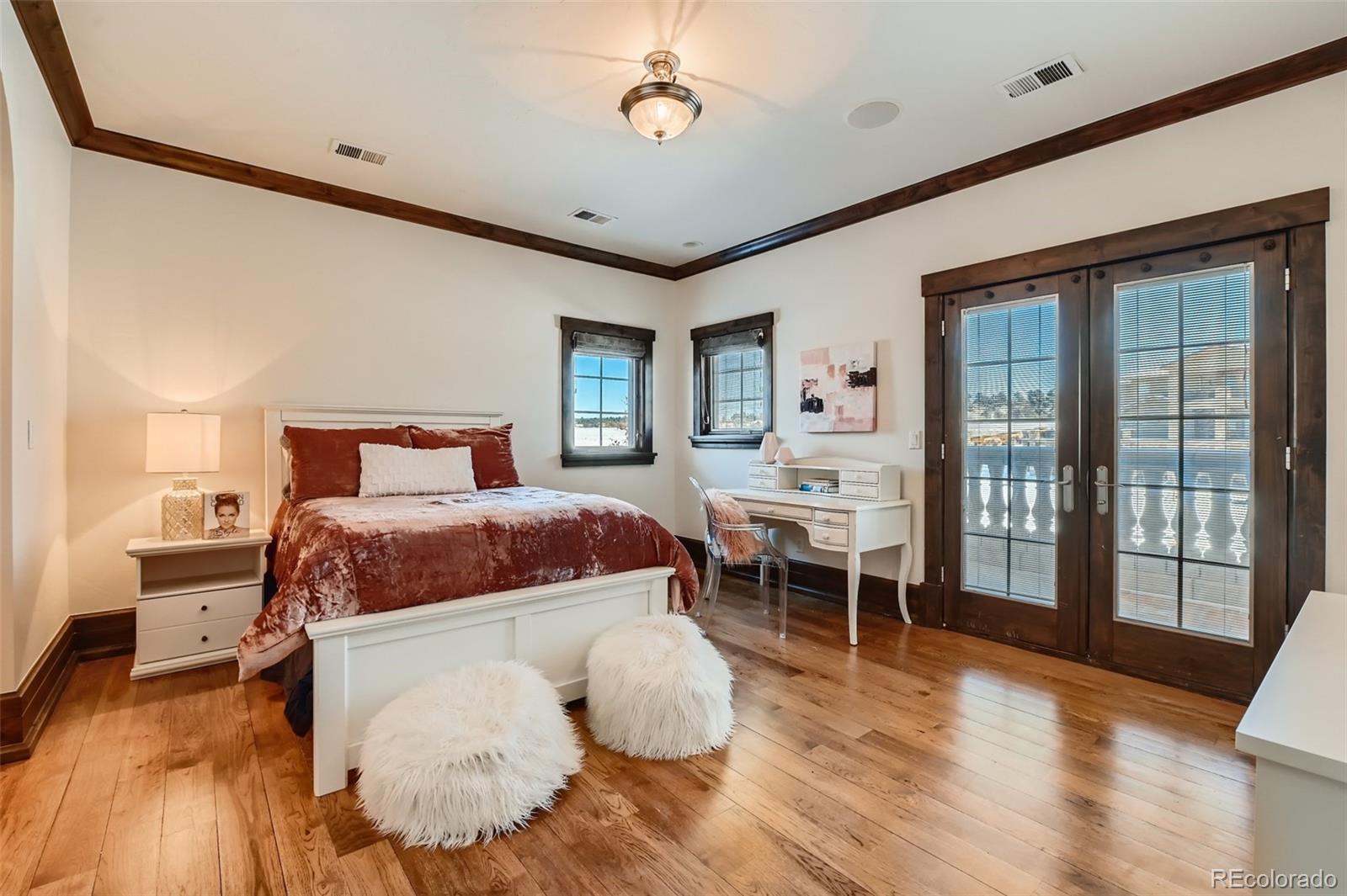 7390 Sagebrush Drive Parker, CO 80138 - Photo 27 of 40 a bedroom with a bed and wooden floor