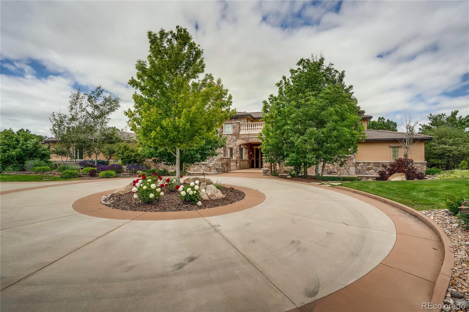 7390 Sagebrush Drive Parker, CO 80138 - Photo 4 of 40 a big white house with a yard and a garden