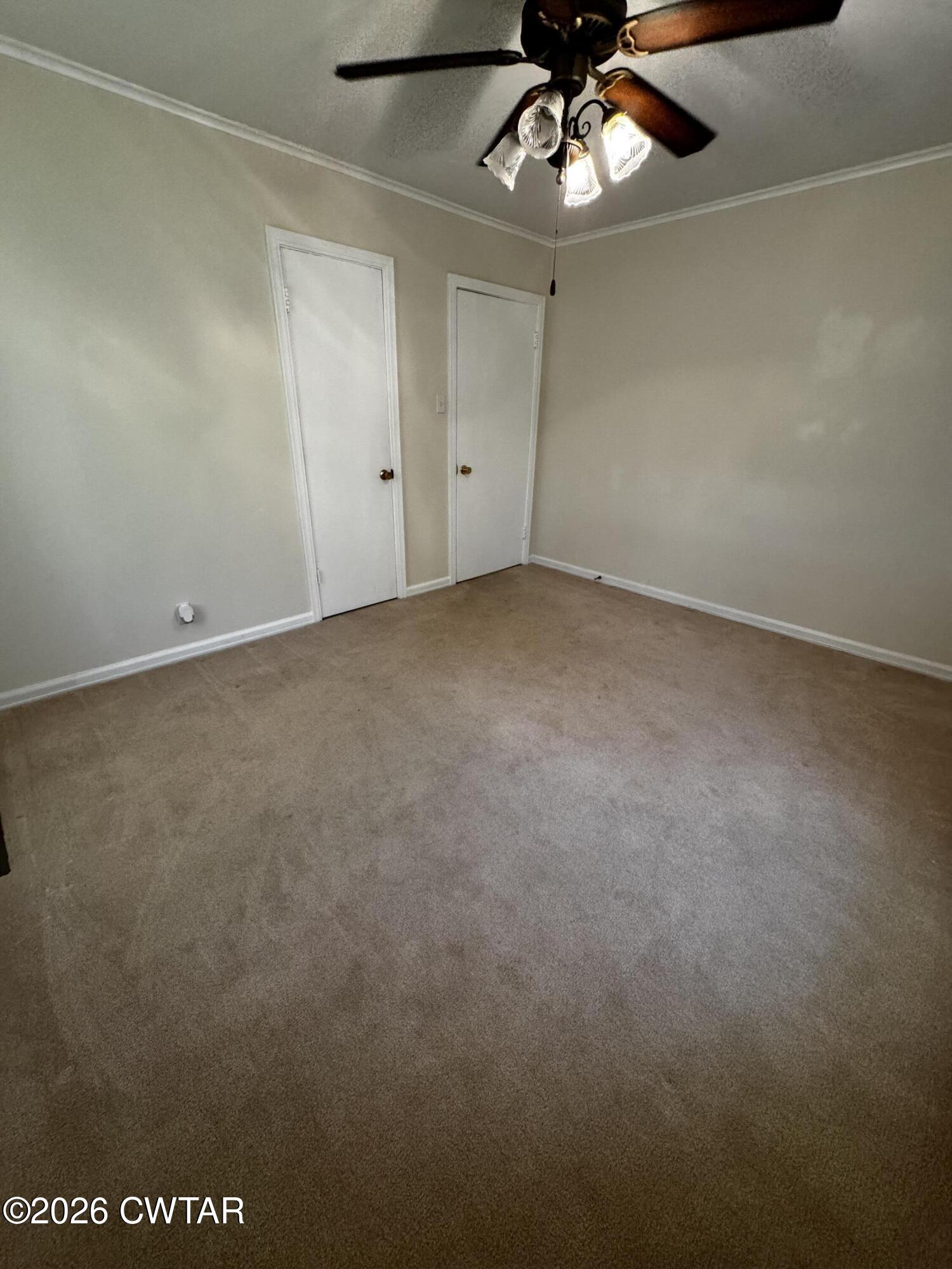 1149 Broad Street Milan, TN 38358 - Photo 17 of 19 an empty room with a chandelier fan and windows