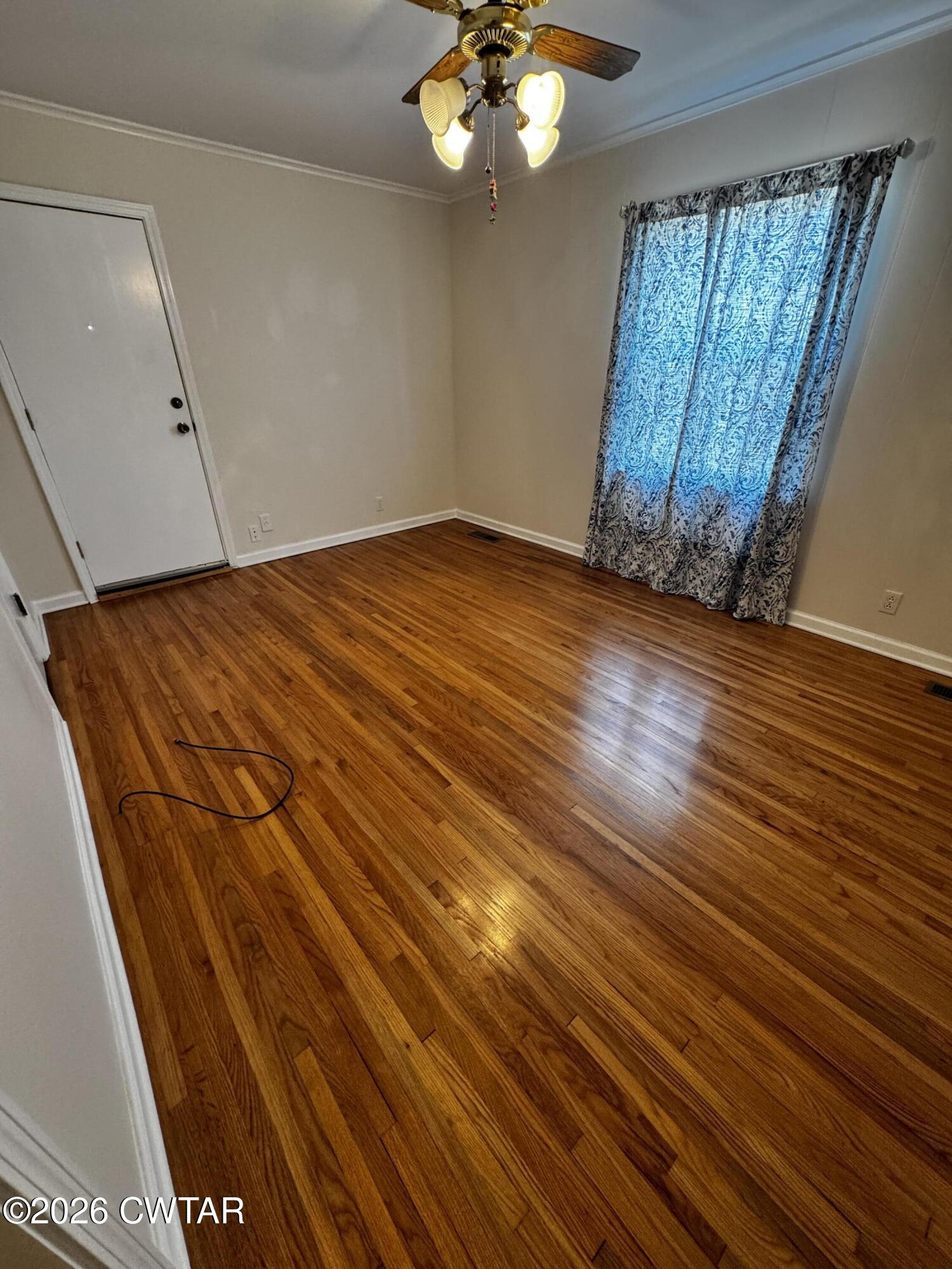 1149 Broad Street Milan, TN 38358 - Photo 19 of 19 a view of an empty room with wooden floor and a window