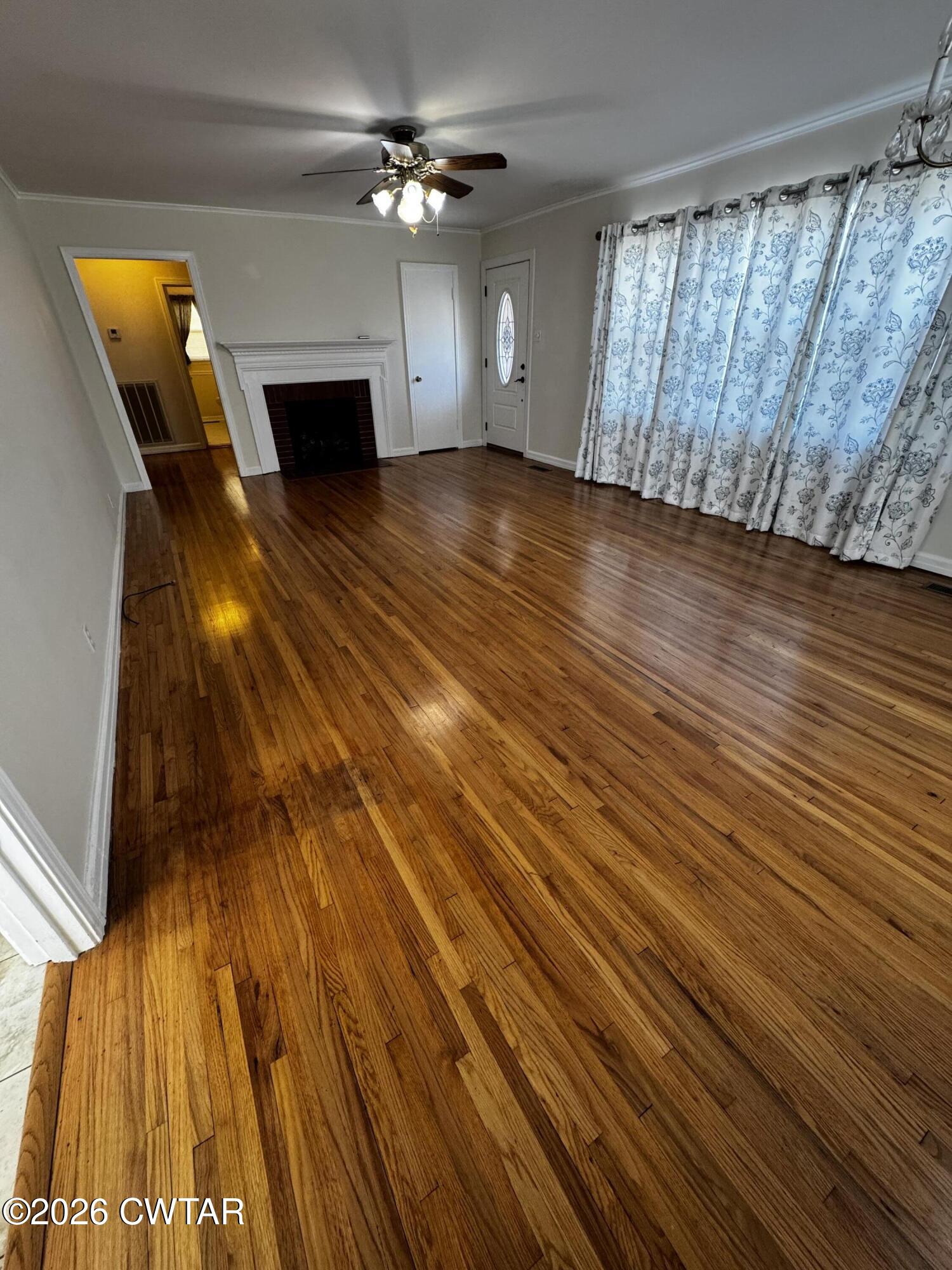 1149 Broad Street Milan, TN 38358 - Photo 8 of 19 a view of empty room with wooden floor and fan