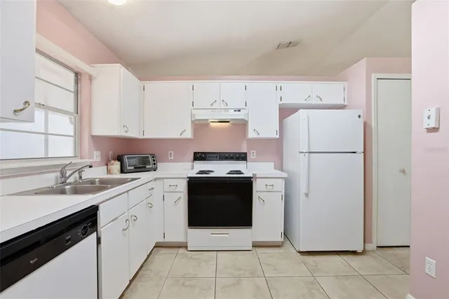 a kitchen with a white stove top oven and refrigerator