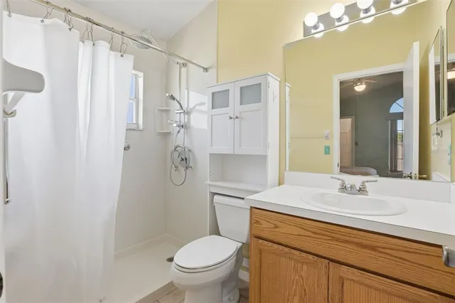 a bathroom with a granite countertop sink toilet and shower